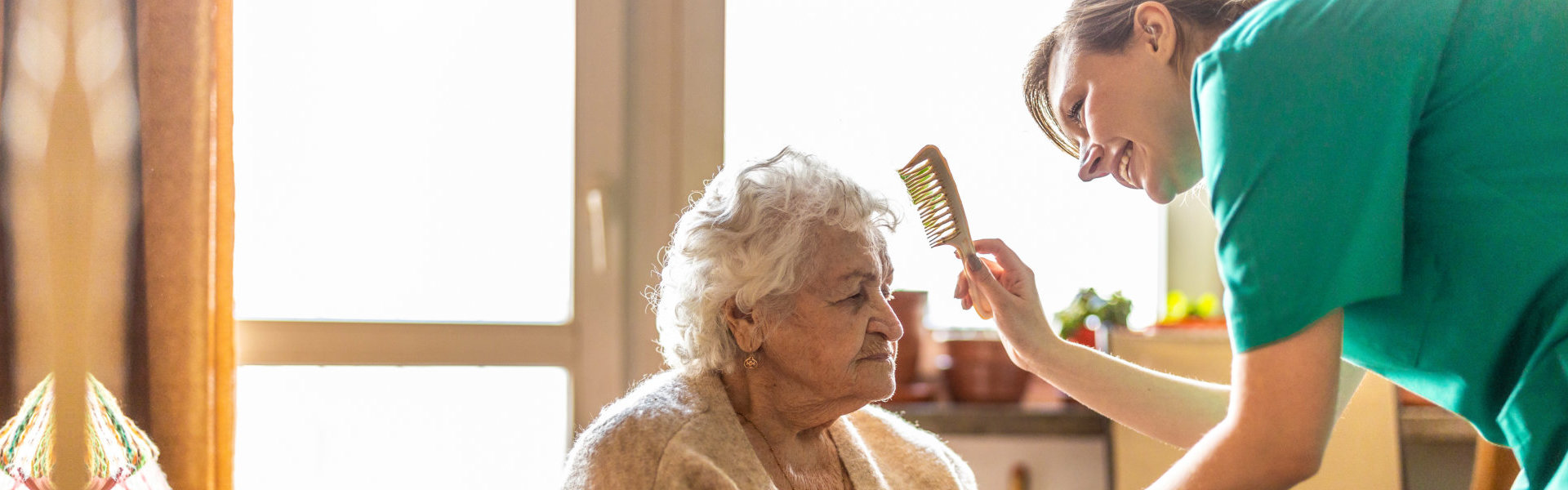 woman combs the hair of a senior woman